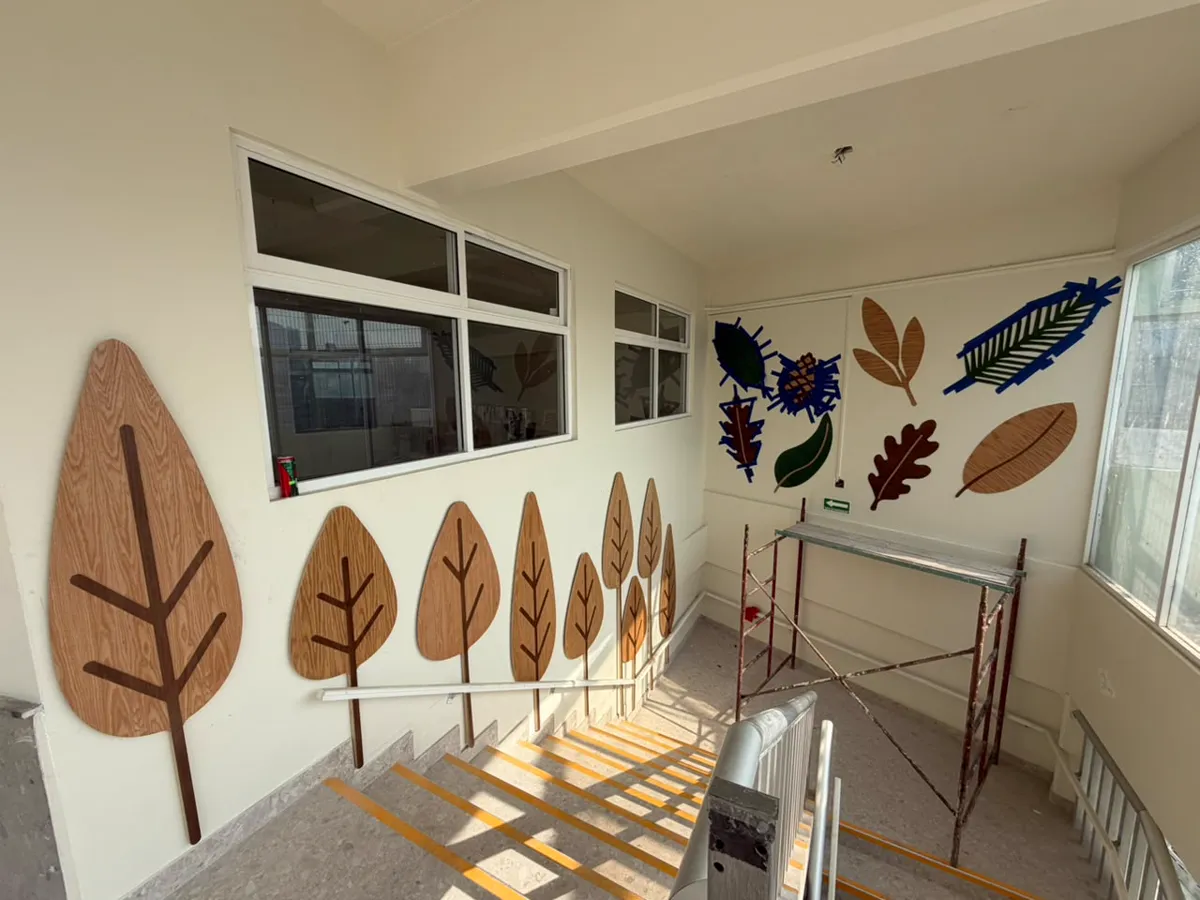 Árboles y hojas cortados en CNC, instalados en el pasillo de una escuela