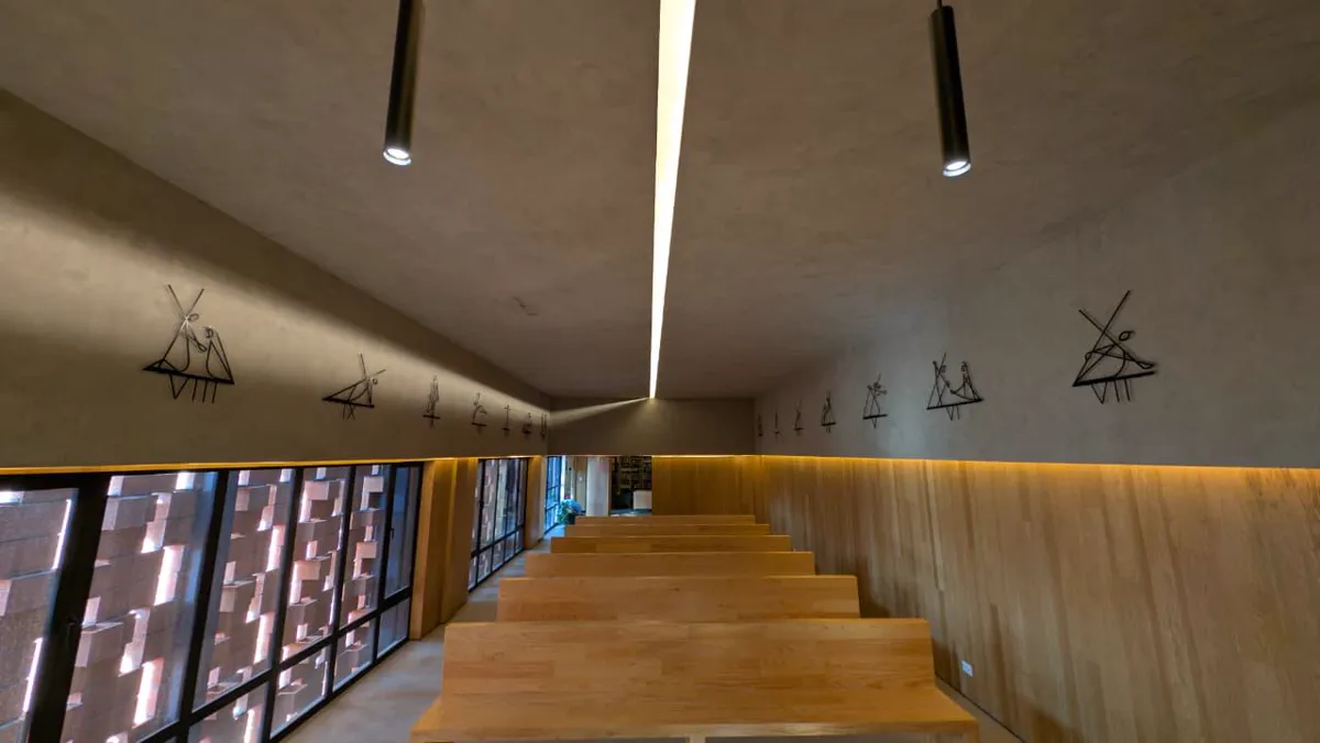 Capilla del Centro Cultural Deiman con las estaciones del vía crucis en acero negro a ambos lados de la nave