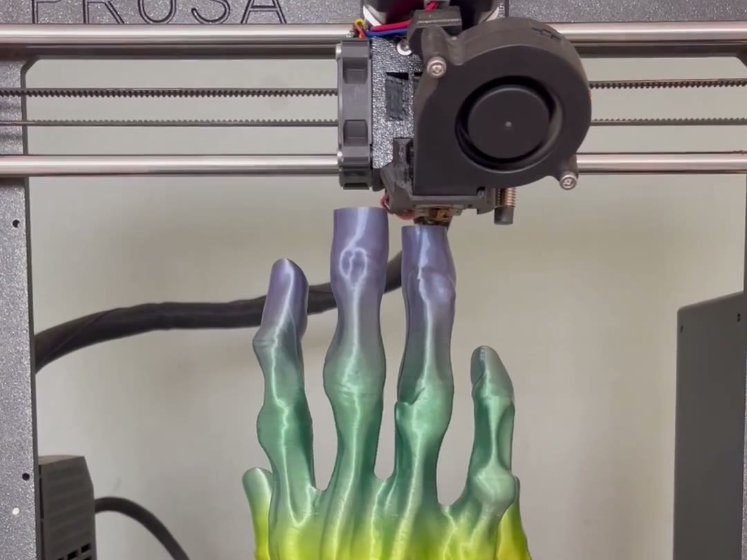 Impresora 3D imprimiendo una mano multicolor